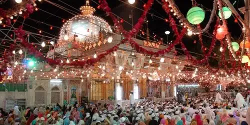 The sacred Ajmer Sharif Dargah beautifully illuminated with colorful lights and vibrant decorations against the night sky in Ajmer, Rajasthan.
