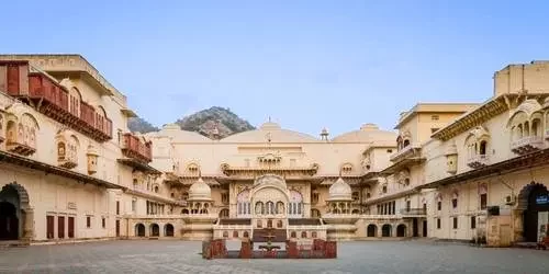 The magnificent Alwar City Palace (Vinay Vilas Mahal) featuring traditional Rajput and Mughal architecture, with intricate marble pavilions and courtyard gardens.