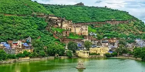 The imposing Taragarh Fort and Garh Palace structure built into the hillside, overlooking the historic blue houses of Bundi, Rajasthan.