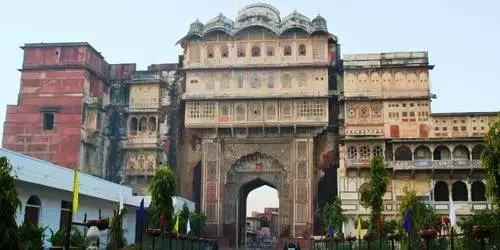The grand facade of the historic Karauli City Palace (Bhanwar Vilas Palace), showcasing intricate red sandstone carvings, classic arches, and traditional Rajput balconies.